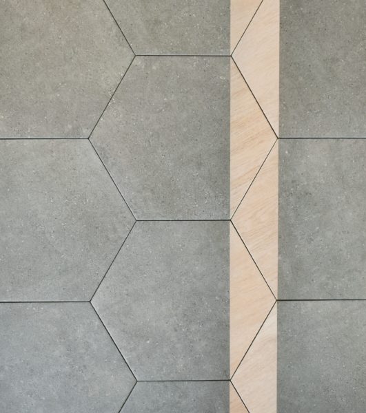 matte graphite porcelain hexagon floor and wall tile with light wood decor detail